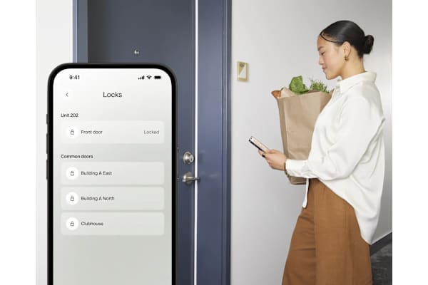 A woman is looking at her phone which displays a lock screen.